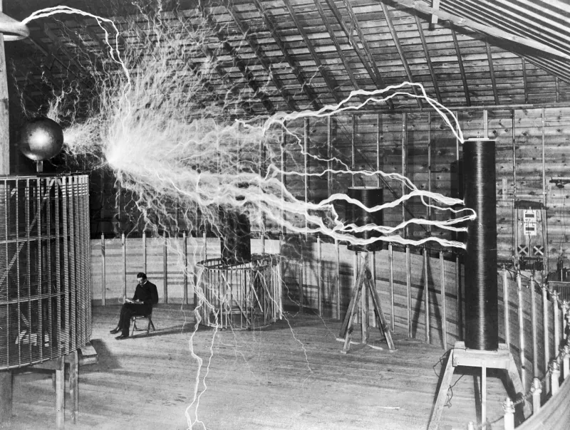 Nikola Tesla in the Colorado Springs laboratory beside electrical apparatus